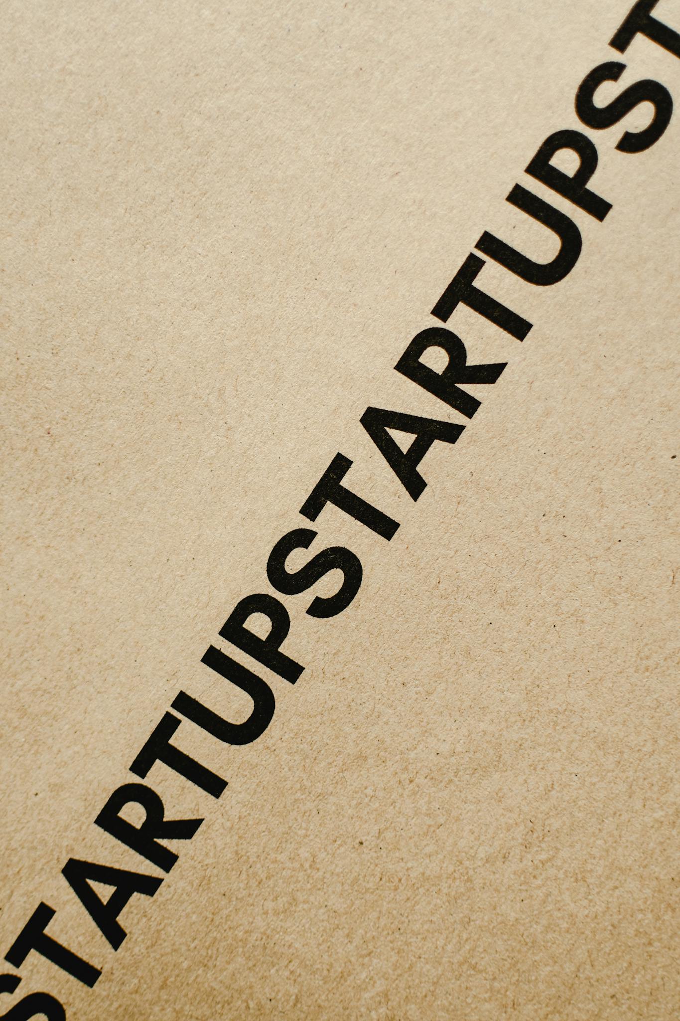 Diagonal black text 'STARTUP' on brown paper, perfect for conceptual business themes.
